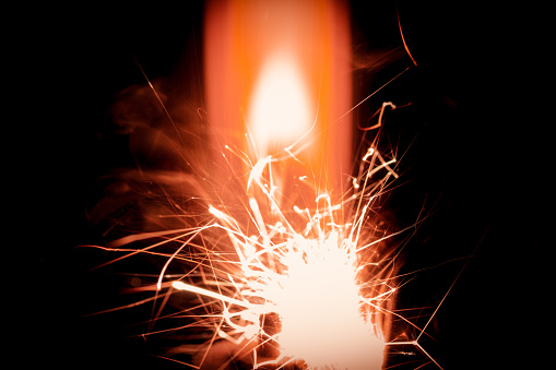 A closeup shot of sparks and a red flame
