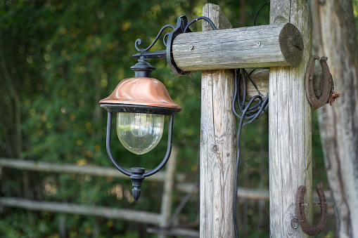 A selective focus shot of a wooden hanging lamp in the street