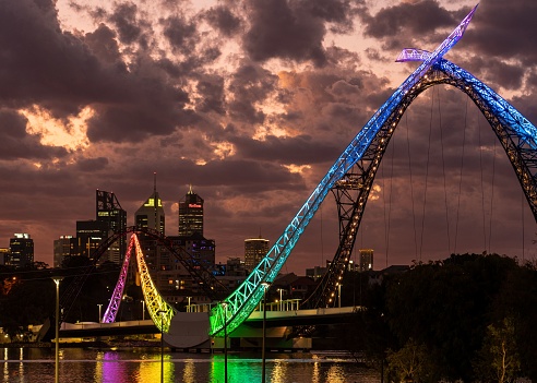Perth, Australia – January 13, 2023: A stunning view of the Matagarup bridge lit up with a rainbow of vibrant colors illuminating across the night sky