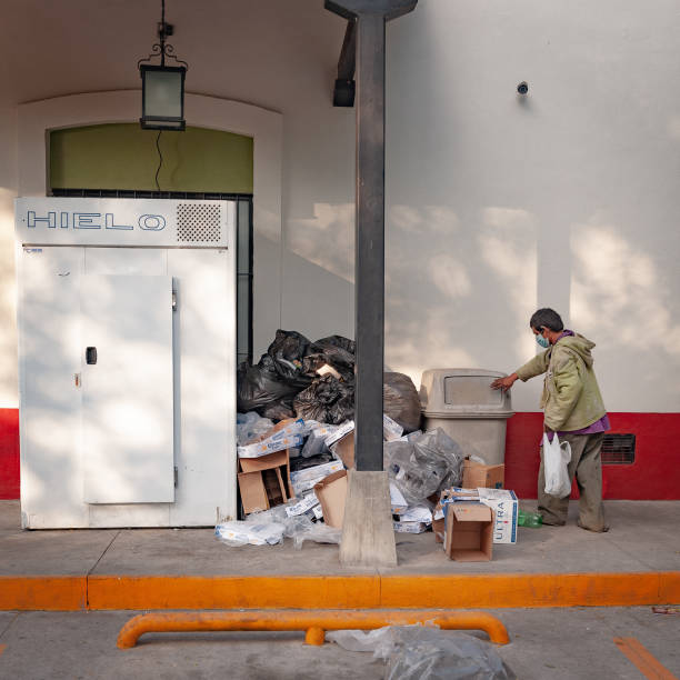 People of Colima Mexico Suchitlan, Mexico – January 31, 2021: Homeless man searches through convenience store trash in rural Colima Mexico during pandemic tienda stock pictures, royalty-free photos & images