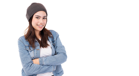 Cool hipster young woman wearing denim jacket beanie hat in winter time Happy smiling lady looking at camera with arms crossed Isolated on white background copy space Pretty girl get confident