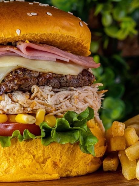istock Delicious cheeseburger served with freshly-sliced tomatoes and corn on the cob, on a tabletop 1479091306