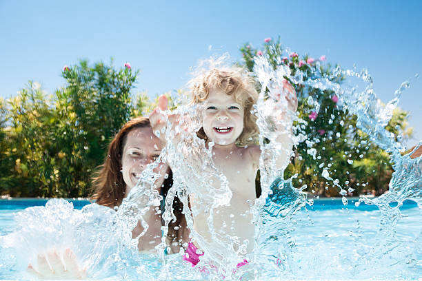 Child with mother in swimming pool stock photo