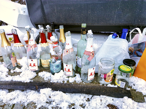 berlin, Germany – January 31, 2021: Berlin, Germany - January 31, 2021: Snow covered glass waste near a recycling container from a Berlin waste company.