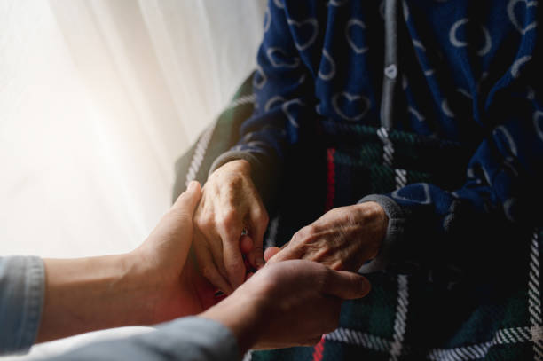 istock Caring grandson holding grandmother's hands 1479094833