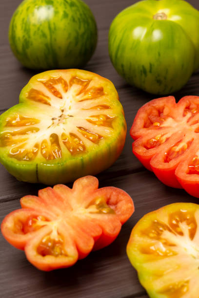 istock Sliced red tomatoes on a wooden background. 1479096414