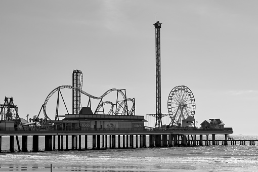 Galveston, Texas, USA - February 2023: Fairground at the end of the city's historic pier in black and white