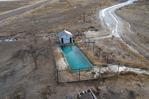 Warm Springs, Nevada, United States – January 31, 2021: A swimming pool filled by naturally hot geothermal spring water sits fenced in at Warm Springs Junction in Central Nevada.