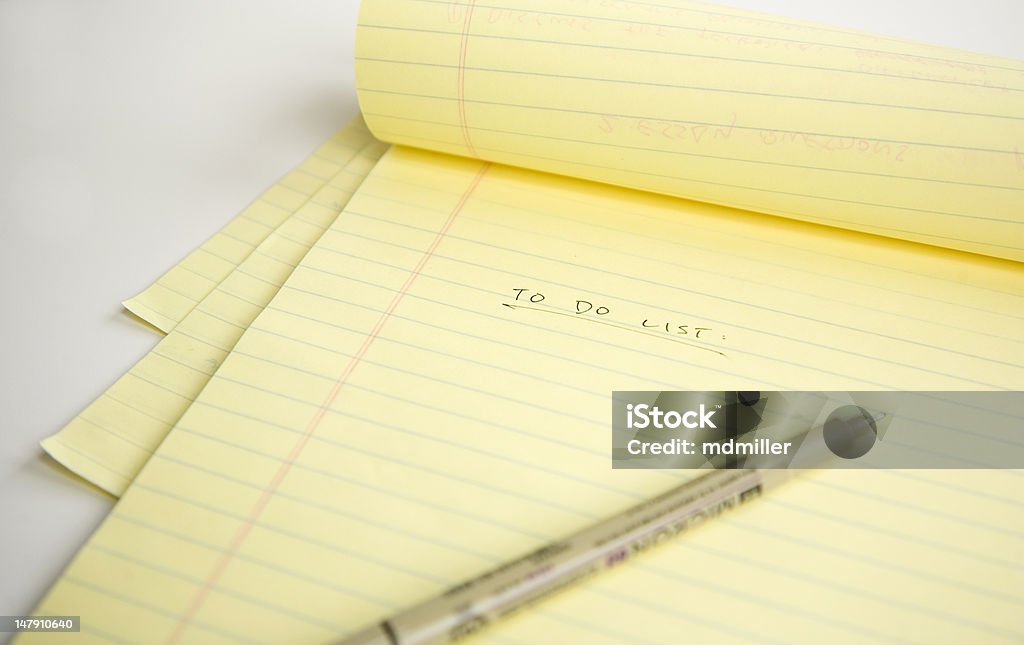 Folded Legal pad and pen A close-up view of a pen on a yellow legal pad with the word To Do List: on the paper. Chores Stock Photo