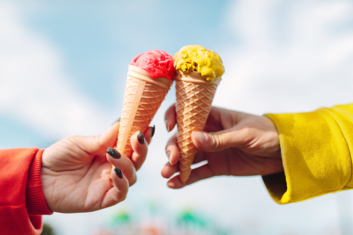 Two woman's hands with ice-cream