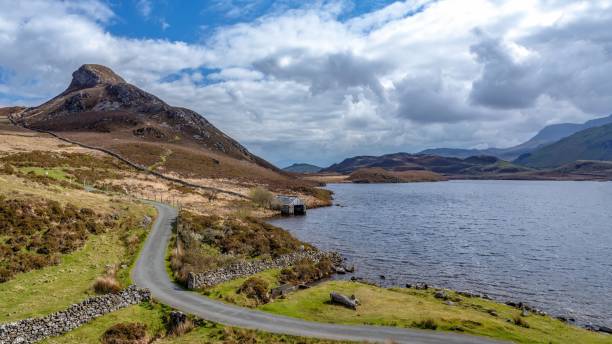 istock an empty country road running through a lush green valley with hills in the background 1479110772