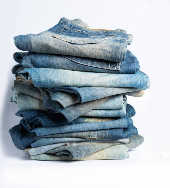 istock Stack of various shades blue jeans. Jeans stacked isolated on white background. Blue denim jeans texture banner with copy space for text design background. Canvas denim fashion texture 1479113068
