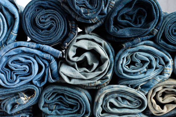 istock Stack of various shades blue jeans. Jeans stacked isolated on white background. Blue denim jeans texture banner with copy space for text design background. Canvas denim fashion texture 1479113102