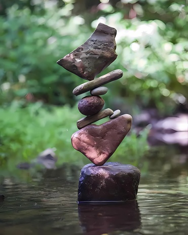 3d rendering balancing rocks in river on green flower or grass background