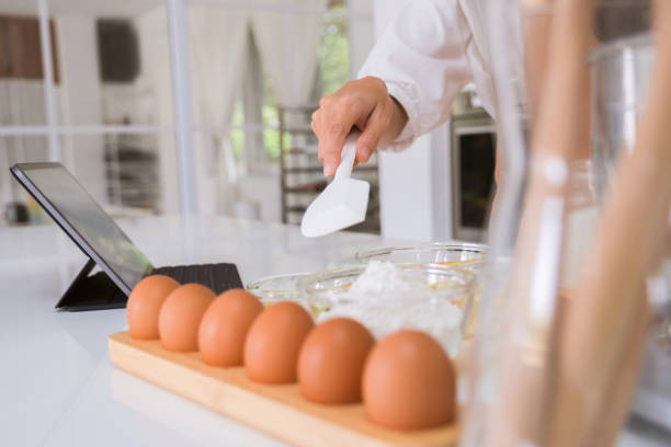 istock Woman making bakery in the kitchen watching tablet. 1479115245