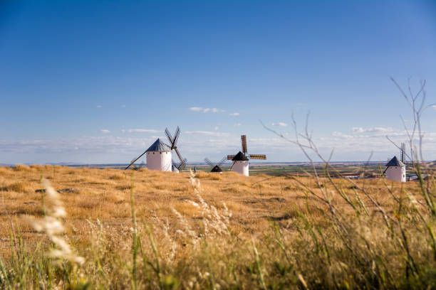 istock Dry field with ancient windmill in Campo de Criptana, Spain, defined in Cervantes' Don Quixote 