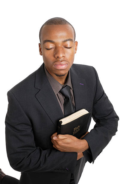 istock Business man on his knees holding a bible 147911919