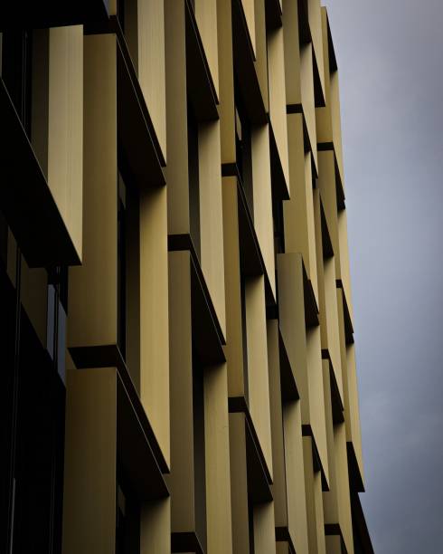 istock Side view of a yellow building illuminated against a cloudy sky. 1479119768