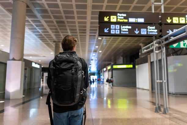 istock Boy carrying his luggage backpack walking through the airport. 1479119826