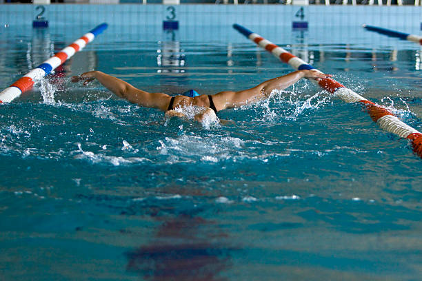 Swimmer girl swims butterfly swimming style in the pool.