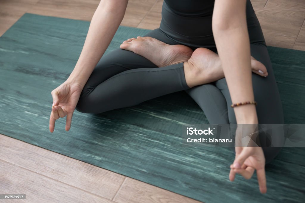 Mudra Apana Vayu Above shoot of apana vayu mudra executed in lotus position by a young woman. 35-39 Years Stock Photo