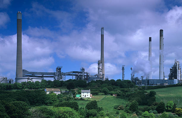 Milford Haven oil refinery Small house dwarfed by the Texaco oil refinery at Milford Haven, Pembrokeshire milford haven stock pictures, royalty-free photos & images