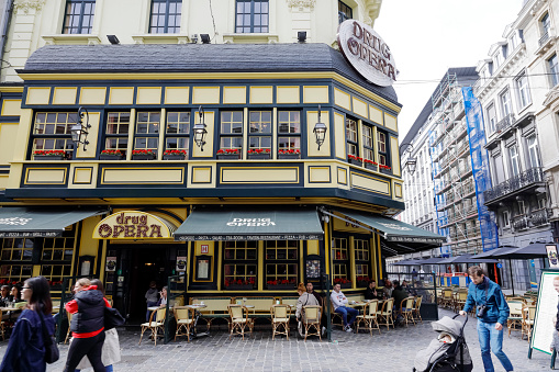 Brussels, Belgium - September 18, 2022: Exterior of a cafe-restaurant called Drug-Opera. The outdoor area of the restaurant is in front of a corner building.