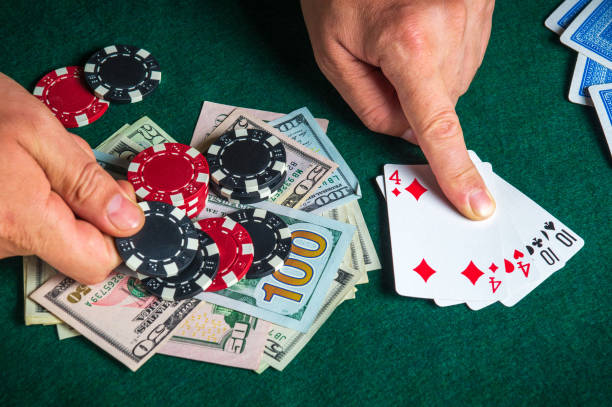 istock Player points with his finger at a winning two pairs combination in poker game on a table with chips and money in a casino 1479134645