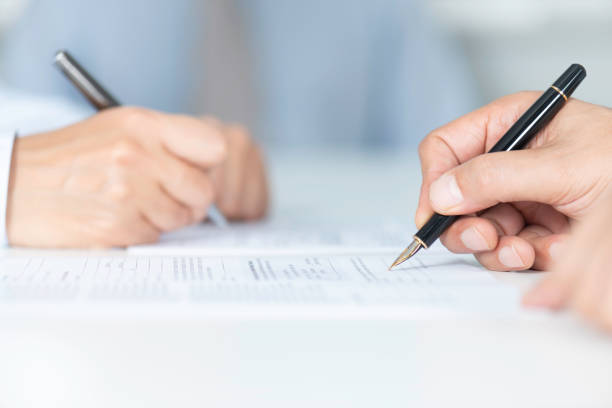Signing Agreement Two business people are signing contract. mergers and acquisitions stock pictures, royalty-free photos & images