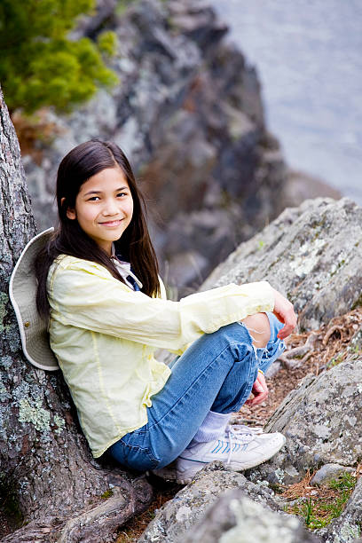 istock Girl sitting on rock cliff edge 147913705