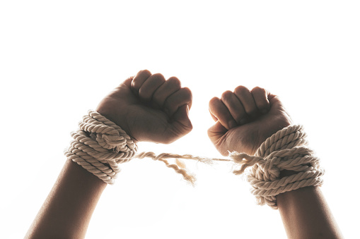 Hands tied up with rope are about to free themselves. Representing freedom speech, freedom of expression issues.