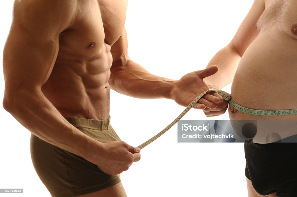 A healthy man measuring a unhealthy mans waist Trainer measures overweight man Abdomen Stock Photo