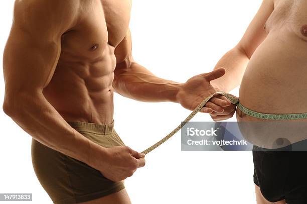 A Healthy Man Measuring A Unhealthy Mans Waist Stock Photo - Download Image Now - Abdomen, Abdominal Muscle, Adult