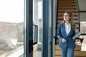 Successful female executive manager ready for business meeting walking in modern office
