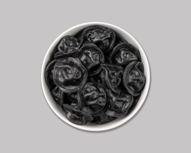 Black dumplings with meat on a gray isolated background. Russian seberian tradition food. Black dumplings with meat on a gray isolated background. Russian seberian tradition food. Top view and copy space. russian pelmeni stock pictures, royalty-free photos & images