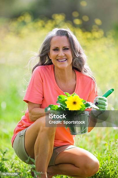 Older Woman Outdoors Holding Flower Pot Stock Photo - Download Image Now - 50-59 Years, Active Lifestyle, Active Seniors