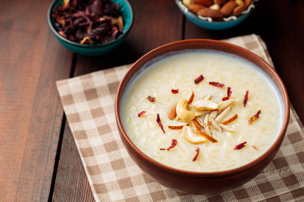 istock Rice pudding served in clay bowl. Indian rice kheer with nuts on a wooden background. Popular Ramadan dish. Top view 1479146549