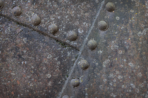 Rusty sheets of metal fastened with large rivets. Background