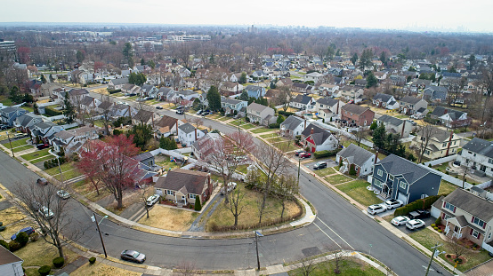 Homes in Middle Class neighborhood, drone point of view at treetop level.