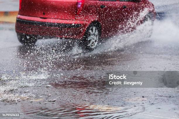 Car Drives Through Puddles And Wet Asphalt Rain Drops Weather Water Splash Flood Stock Photo - Download Image Now