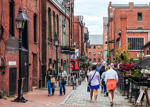 Portland, Maine, USA - People walking the street lined with shops and pubs in the Old Port district.
