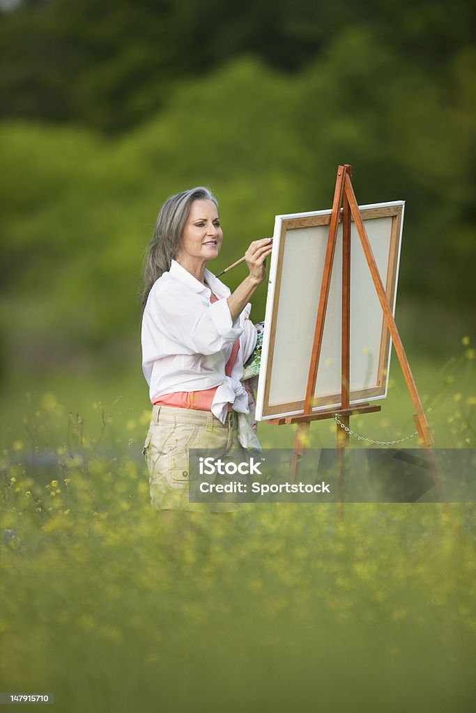 Kobieta Malowanie Sztaluga w Dziki kwiat pole - Zbiór zdjęć royalty-free (Łubin błękitny)