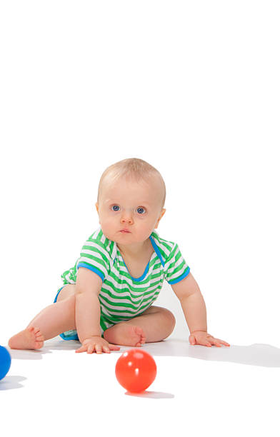 istock Young child isolated on white reaching for colored balls. 147915852