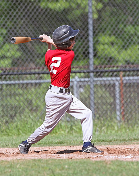 istock Young boy in a swing motion hitting a baseball 147915876