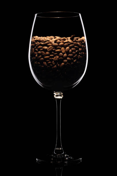 istock Coffee beans in wine glass isolated on black background 1479160839