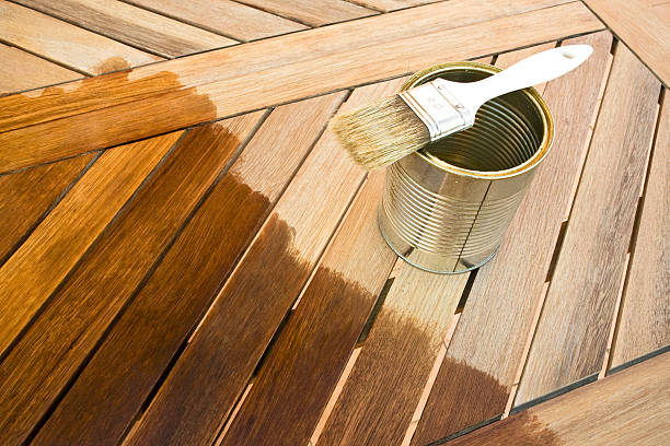 istock A paint can and brush on a brown partially stained deck 147916575