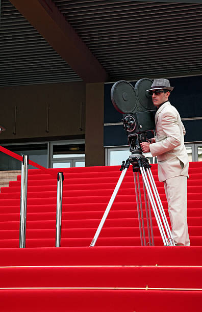 Cameraman on Red Steps Young man filming on red carpeted steps of the Palais des Festivals in Cannes. cannes film festival stock pictures, royalty-free photos & images