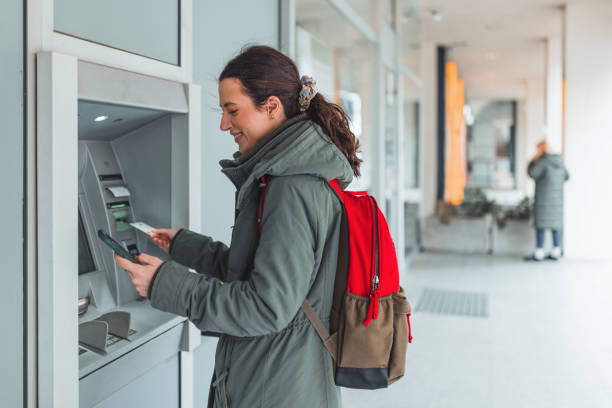 une femme retire facilement de l’argent au guichet automatique - atm human hand bank real people photos et images de collection