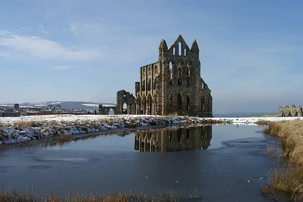 View of Whitby Abbey across the monastic fishponds in the snow