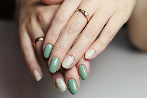 Female hands with nail design close-up. Beautiful female nails with green manicure